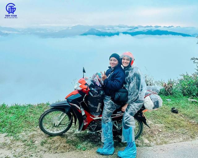 Achterop op de motor bij een uitzichtpunt boven een zee van wolken op de Ha Giang Loop
